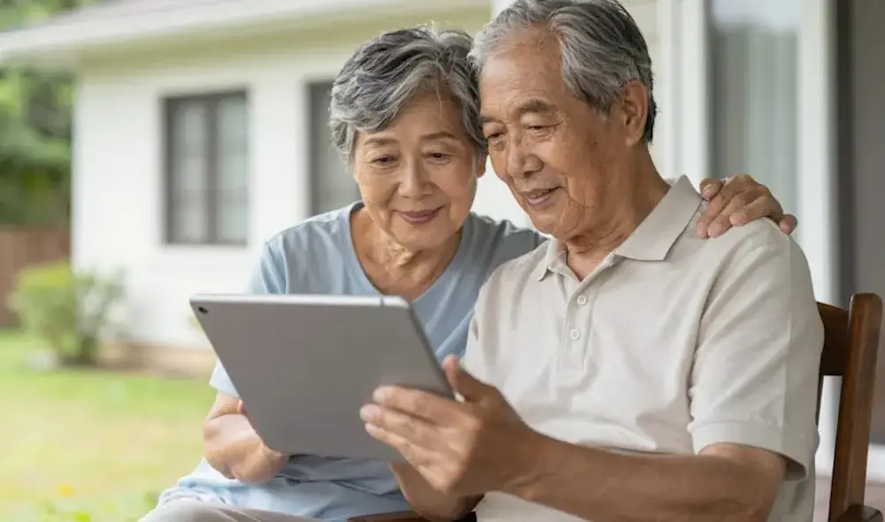 Senior couple using a tablet on a porch